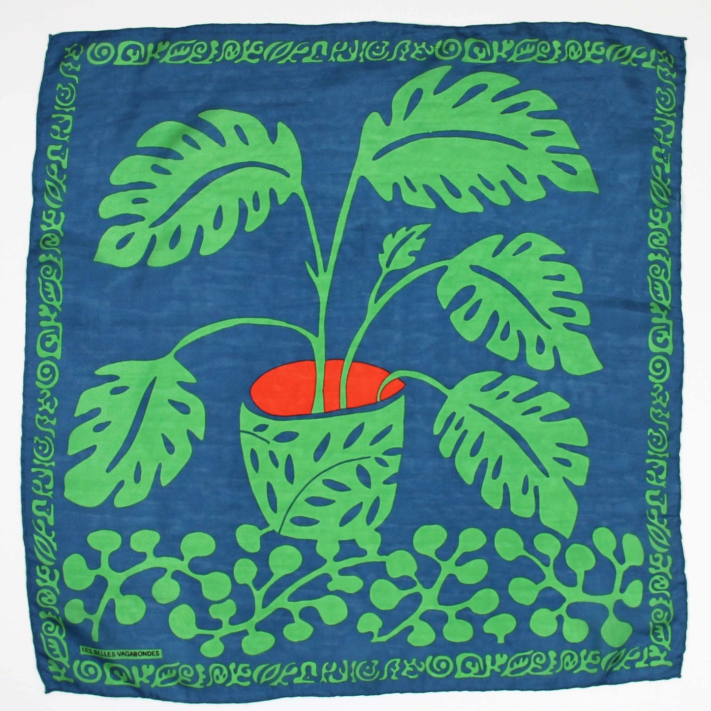 Foulard carré en soie avec dessin d'une plante de type Arum , dans les tons vert, bleu et orange. 