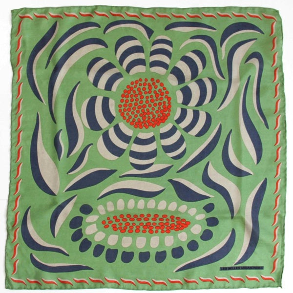 Foulard carré en soie avec dessins de fleurs et feuilles, dans les tons vert, bleu foncé, écru et des touches de orange. 