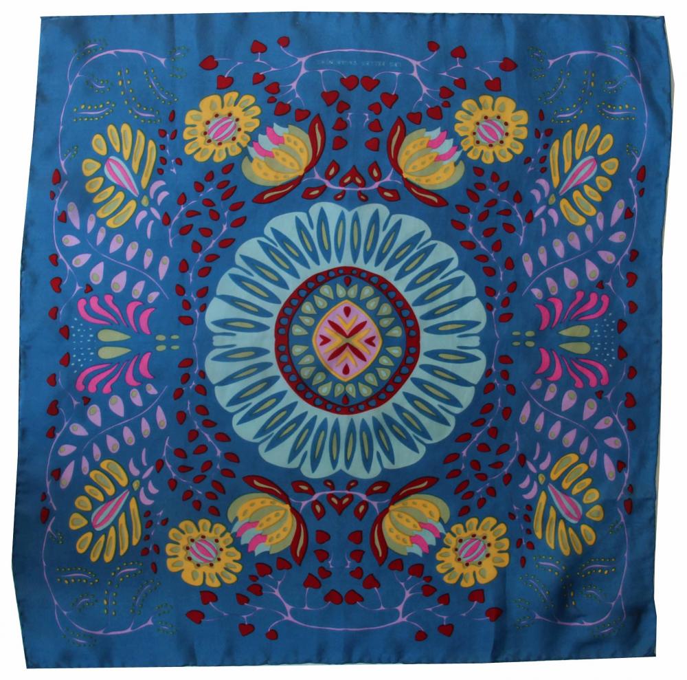 Foulard carré en soie avec motif floral comme un mandala, dans les tons bleu, jaune, rose et rouge.