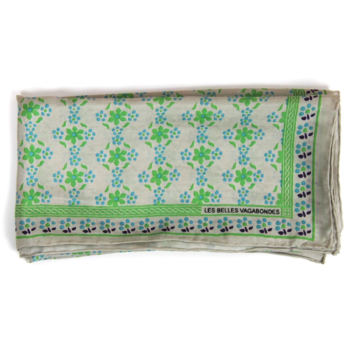 Foulard carré en soie avec motif floral, dans les tons écru, vert flashy, bleu ciel et des touches de noir.