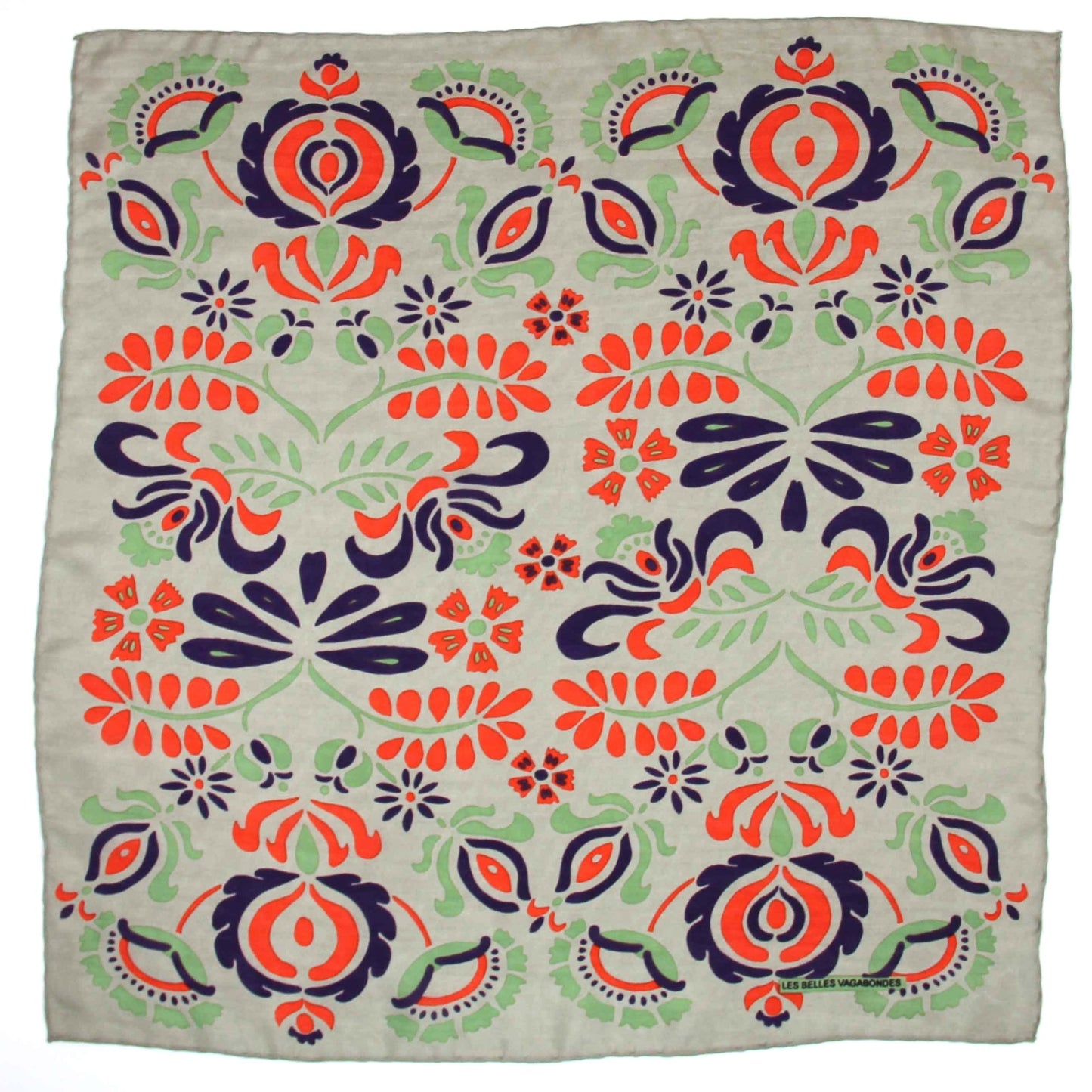 Foulard carré en soie avec motif floral, dans les tons écru, vert amande, orange vif et bleu foncé. 