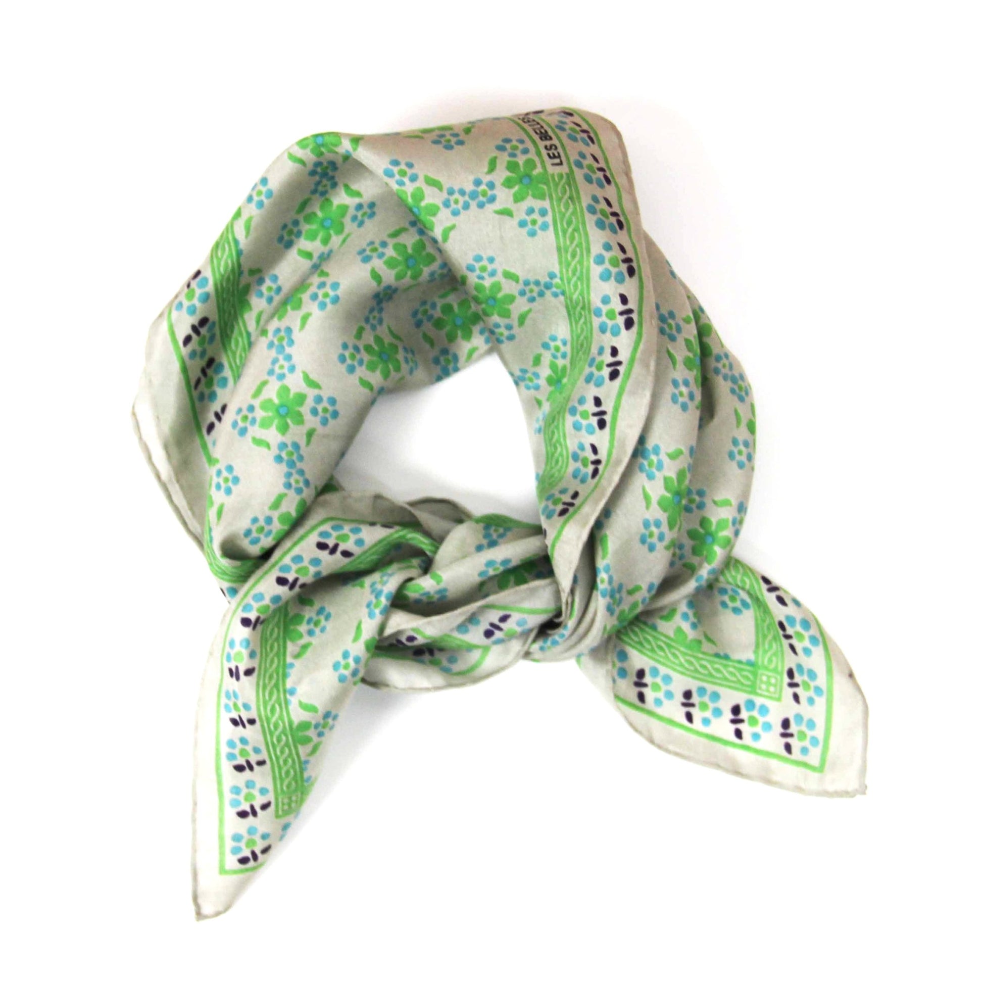 Foulard carré en soie avec motif floral, dans les tons écru, vert flashy, bleu ciel et des touches de noir.