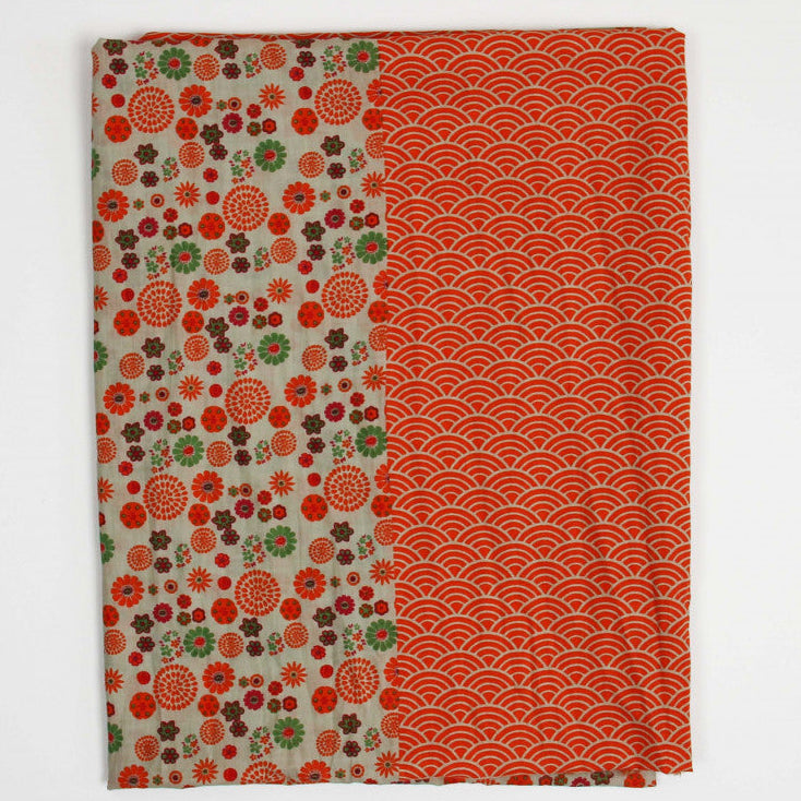 Foulard en coton bio, modèle Kohana, motif vagues et fleuri, coloris orange, beige et vert. 