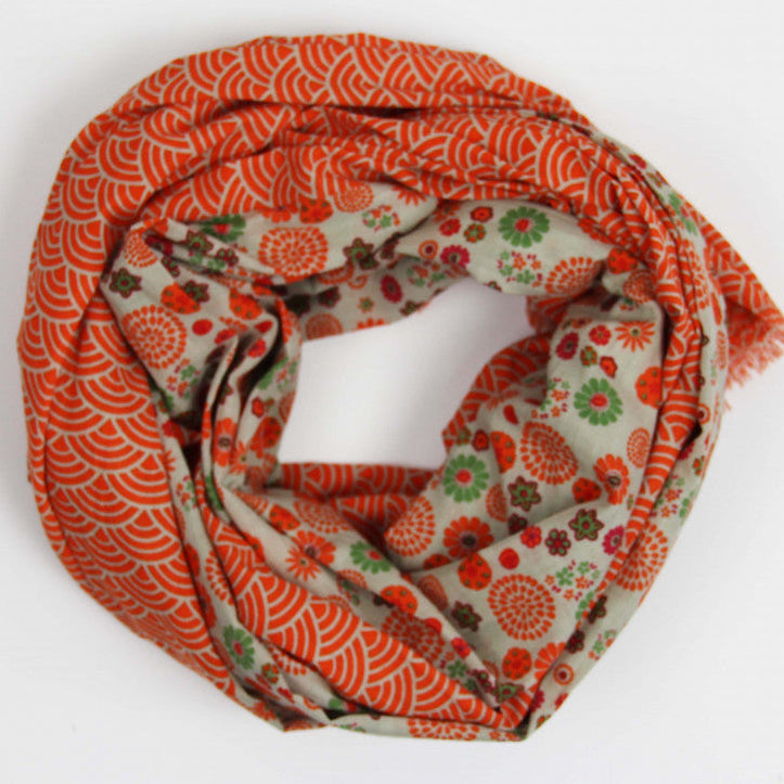 Foulard en coton bio, modèle Kohana, motif vagues et fleuri, coloris orange, beige et vert. 