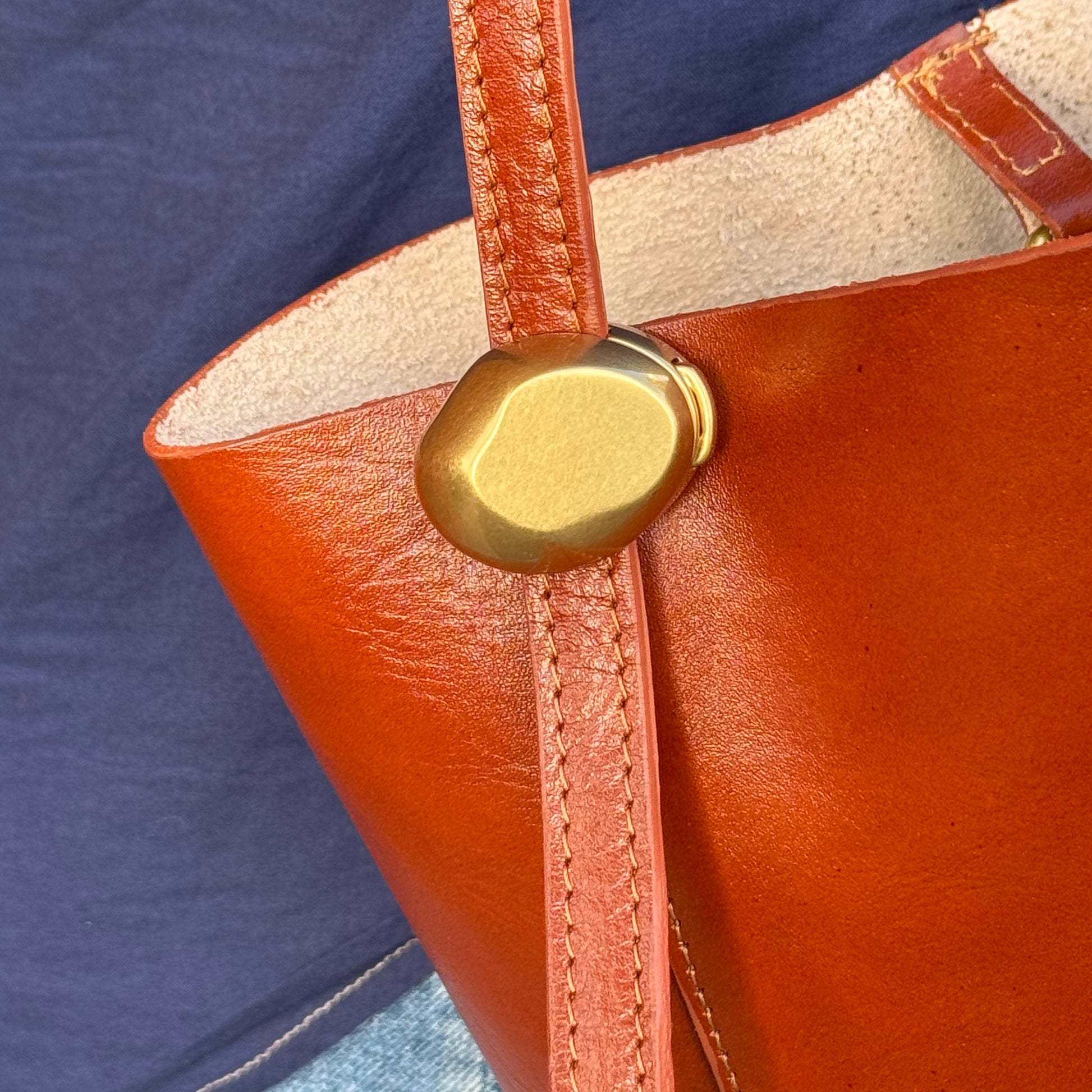 Grand sac seau en cuir, détail du réglage de la bandoulière.