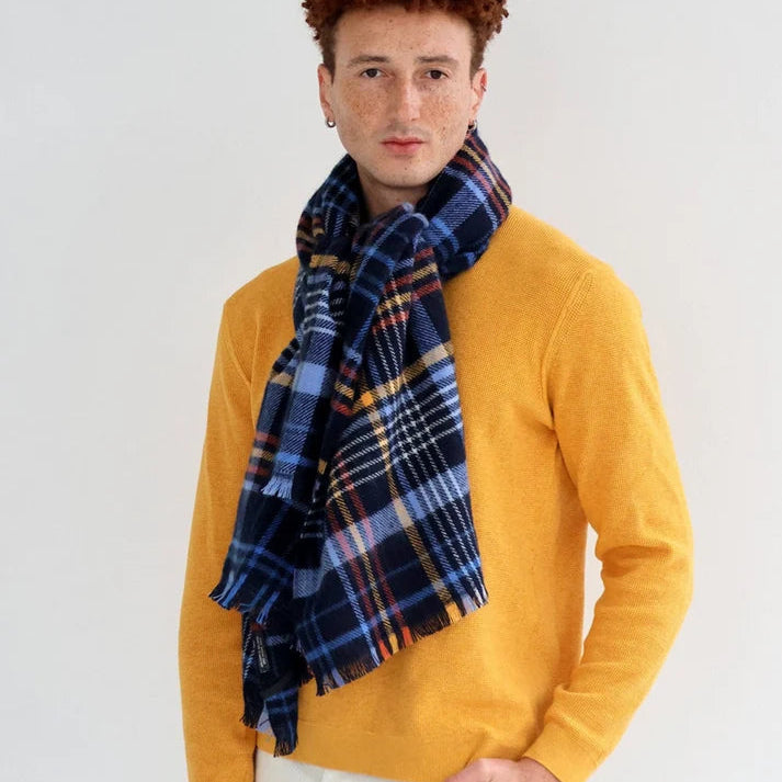 Maxi écharpe en laine avec motif tartan écossais, dans les tons bleus foncés.