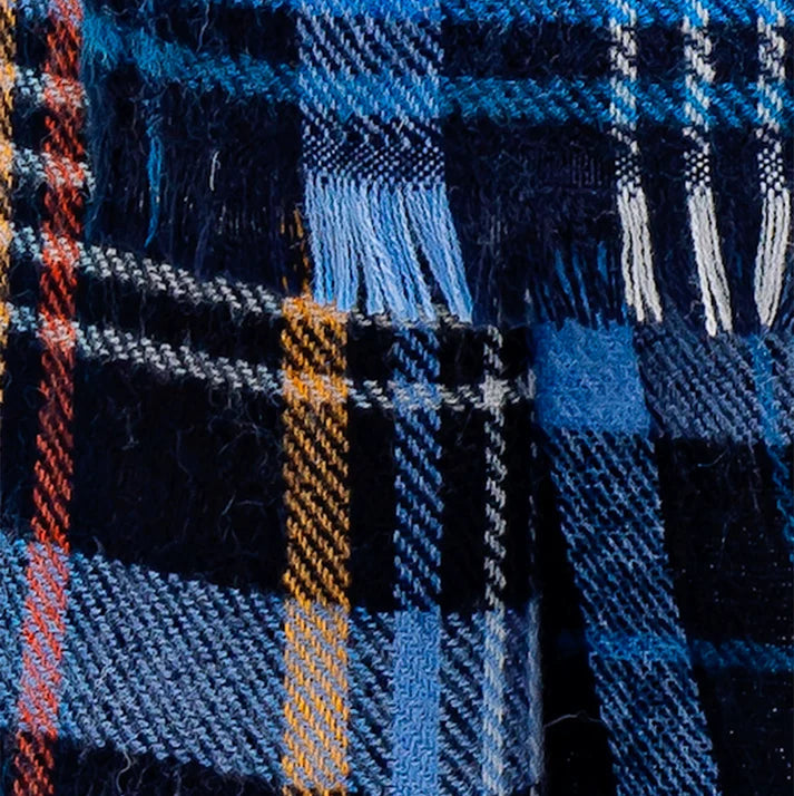 Maxi écharpe en laine avec motif tartan écossais, dans les tons bleus foncés.