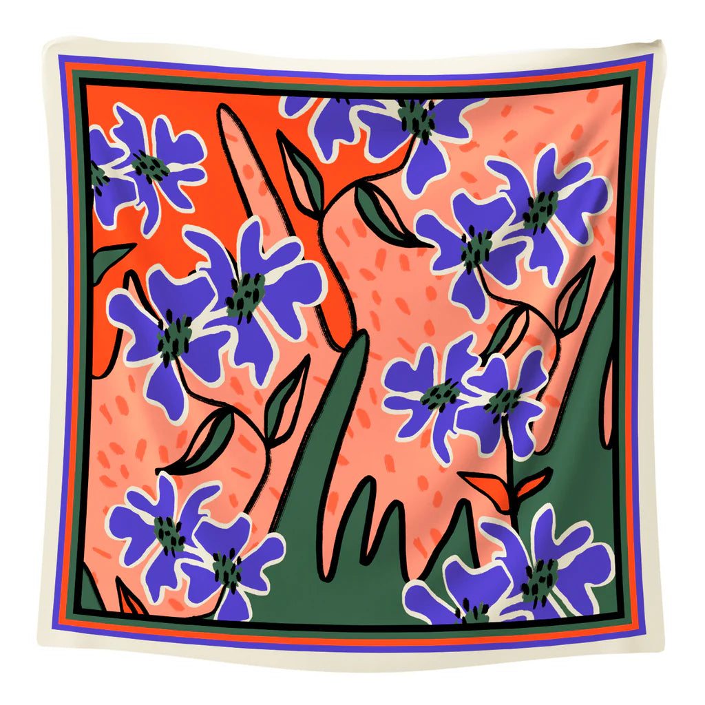Maxi foulard en satin avec une illustration de fleurs bleues sur fond rose.