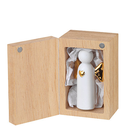 Mini ange en porcelaine blanche avec les ailes dorés posé dans sa boîte.