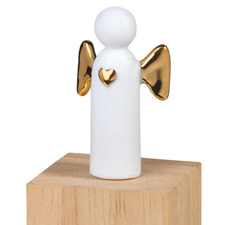 Mini ange en porcelaine blanche avec les ailes dorés posé sur sa boîte.