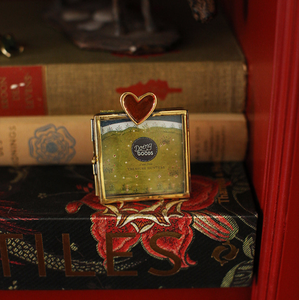 Mini cadre photo en laiton doré avec un coeur rouge incrusté.