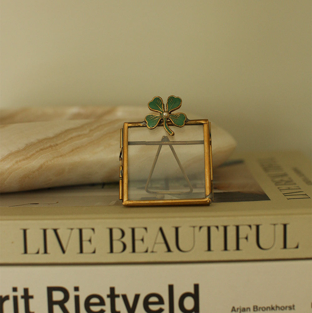 Mini cadre photo en laiton doré avec un trèfle vert incrusté.