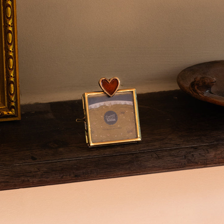Mini cadre photo en laiton doré avec un coeur rouge incrusté.