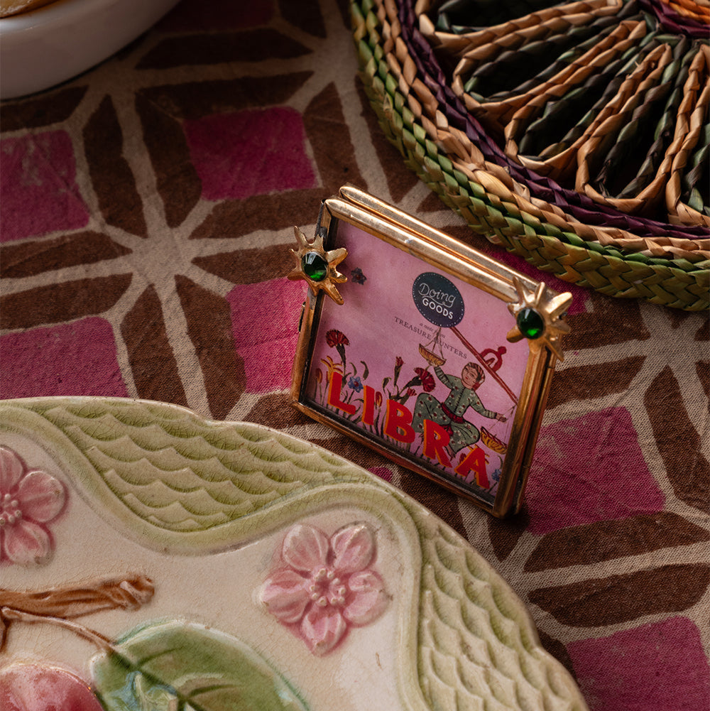 Mini cadre photo en laiton doré avec des étoiles vertes incrustées.