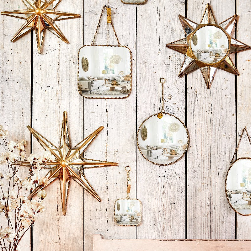 Composition murale de différentes formes de miroirs : carrée, ronde, ovale et en étoiles.