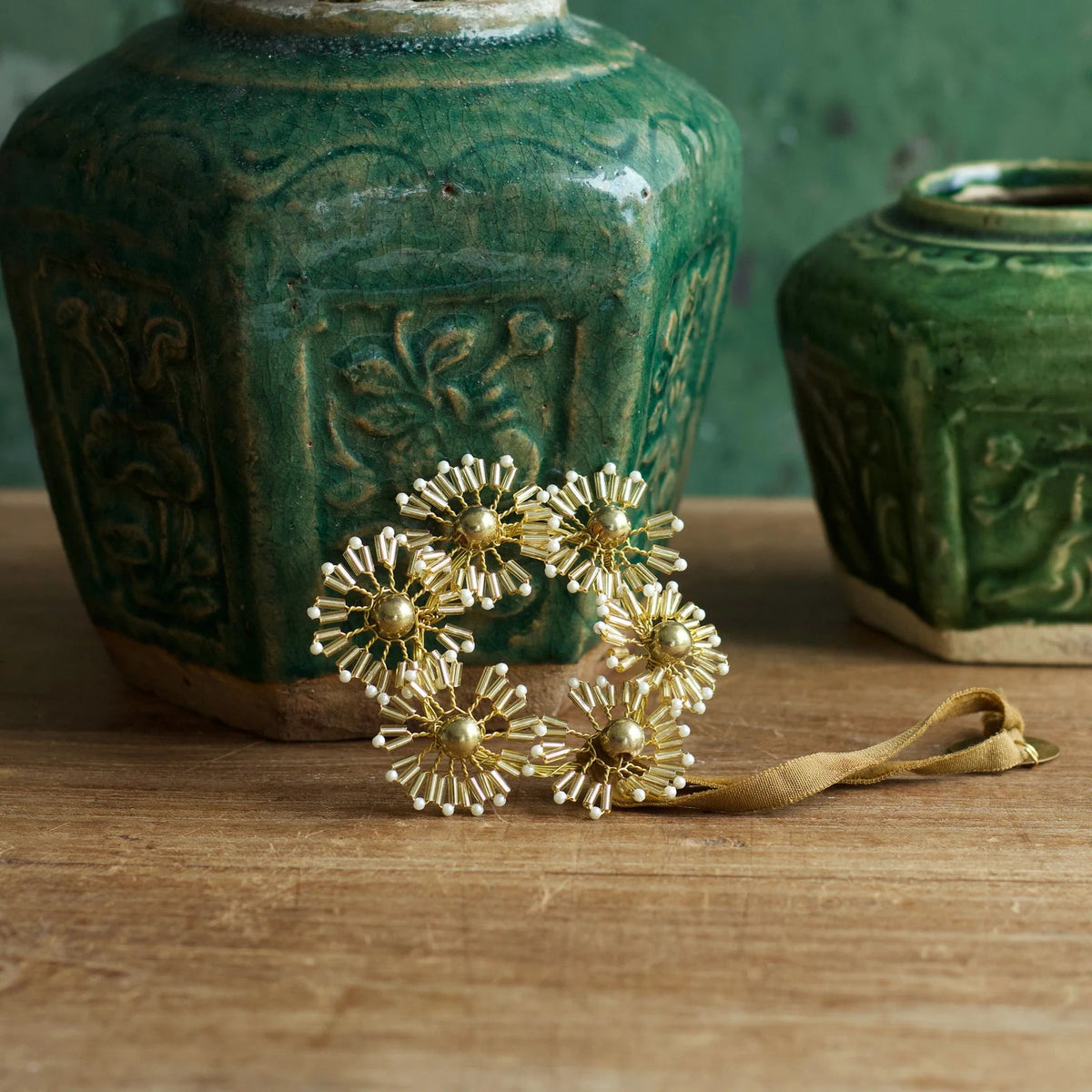 Petites fleurs en fils et perles dorées et blanches à supendre en décoration de Noël.