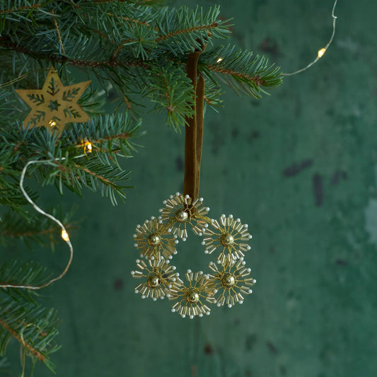 Petites fleurs en fils et perles dorées et blanches à supendre en décoration de Noël.