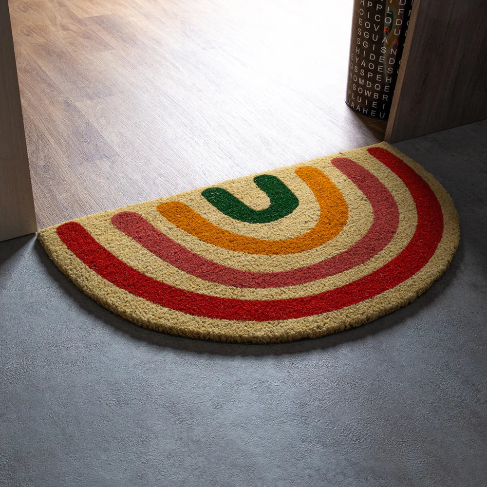 Paillasson semi-circulaire avec dessin arc-en-ciel en fibres de coco.