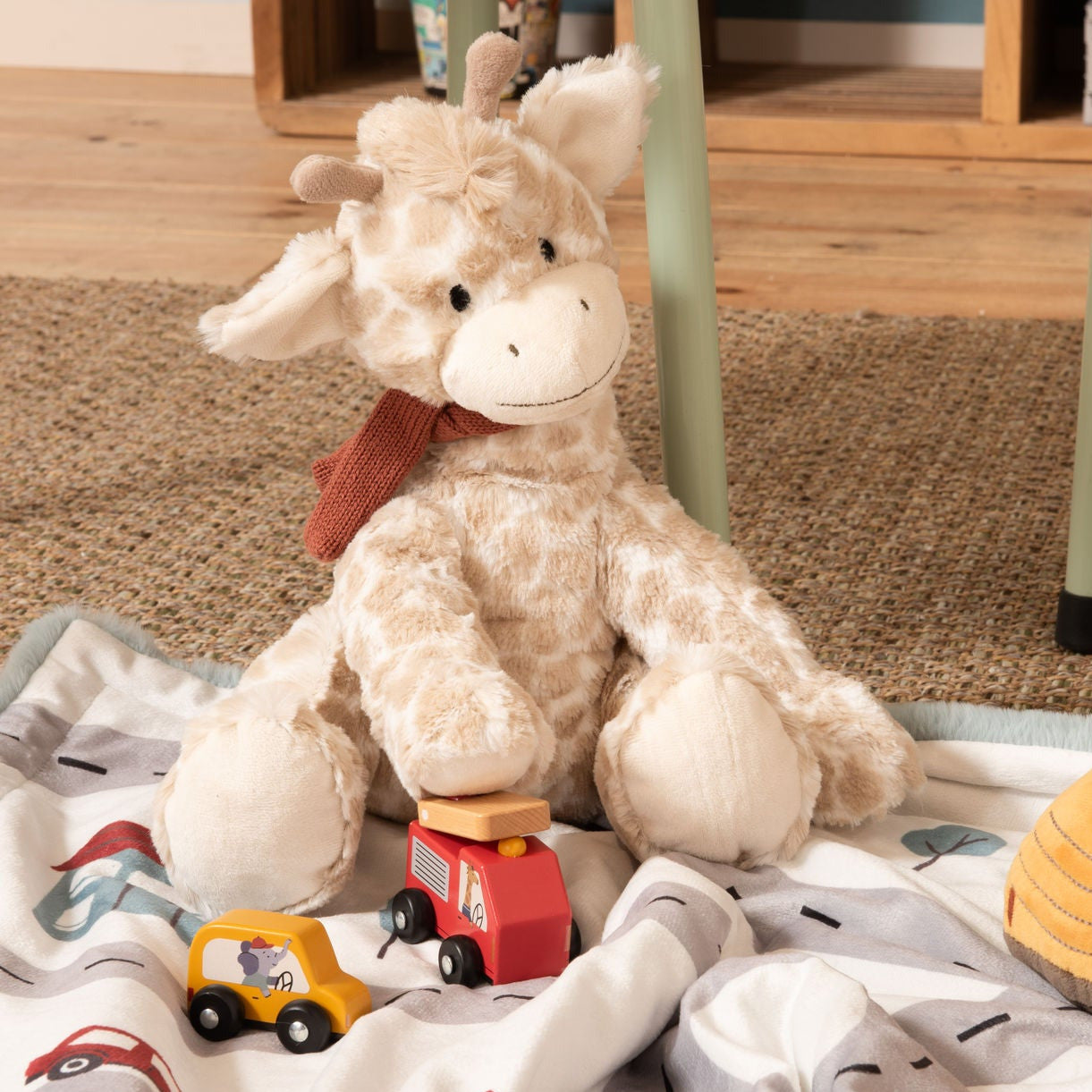 Peluche toute douce en forme de girafe avec une petite écharpe tricotée.