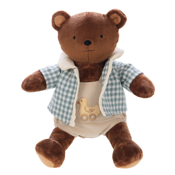 Peluche toute douce en forme d'ourson avec un haut beige et une chemise à carreaux bleus.