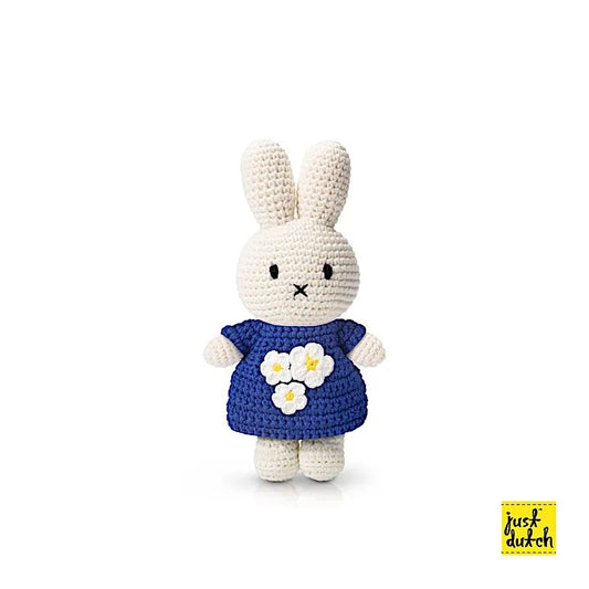 Peluche en crochet Miffy avec une robe bleue et des fleurs blanches.