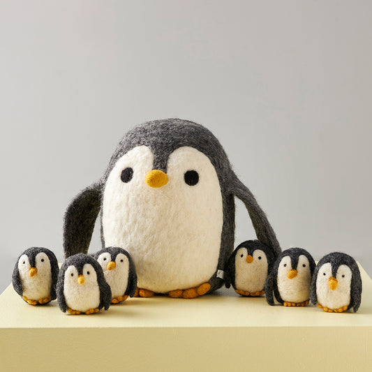 Peluche en laine feutrée en forme de pingouin mignon, de couleurs gris et blanc.