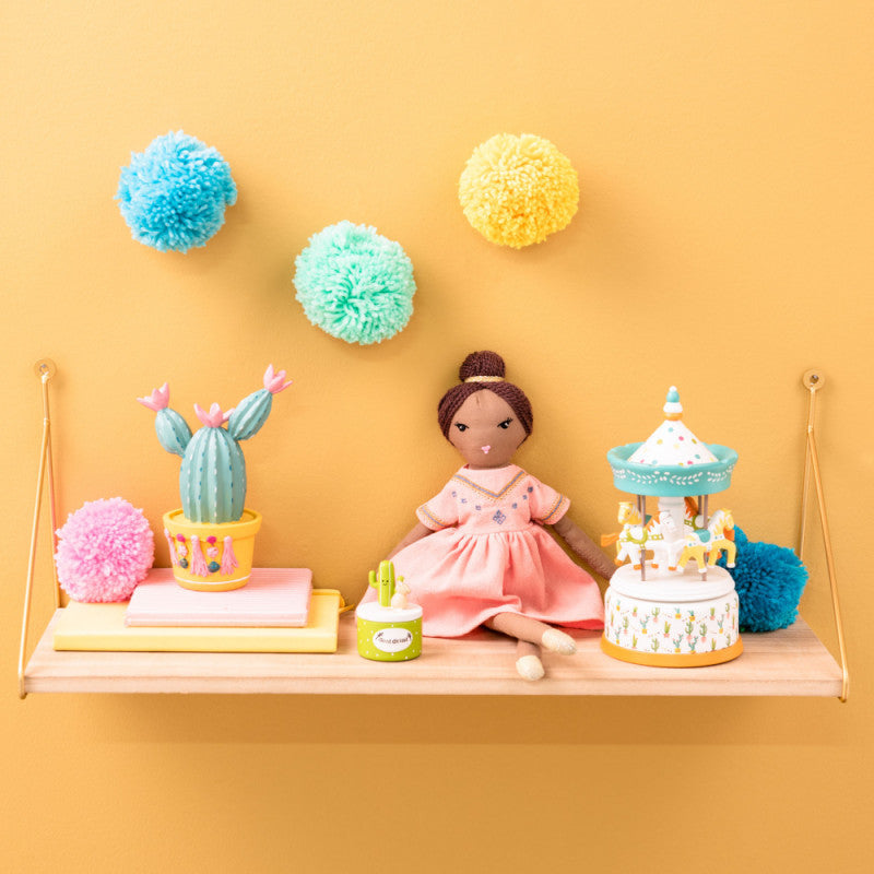 Peluche en forme de poupée avec une robe rose et un chignon.