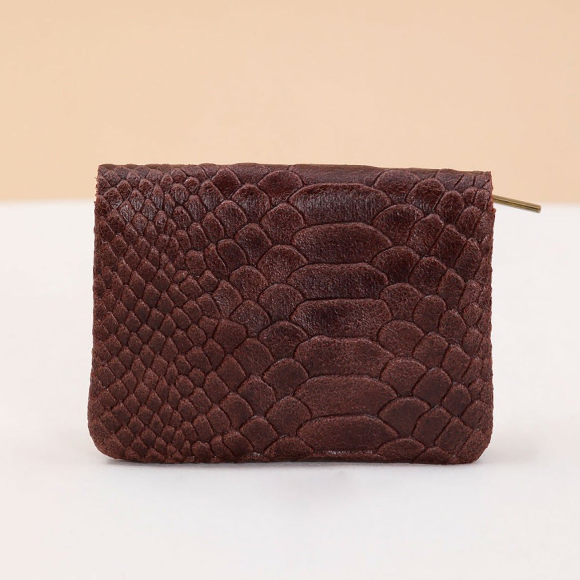 Petit porte-monnaie en cuir effet python, coloris marron.