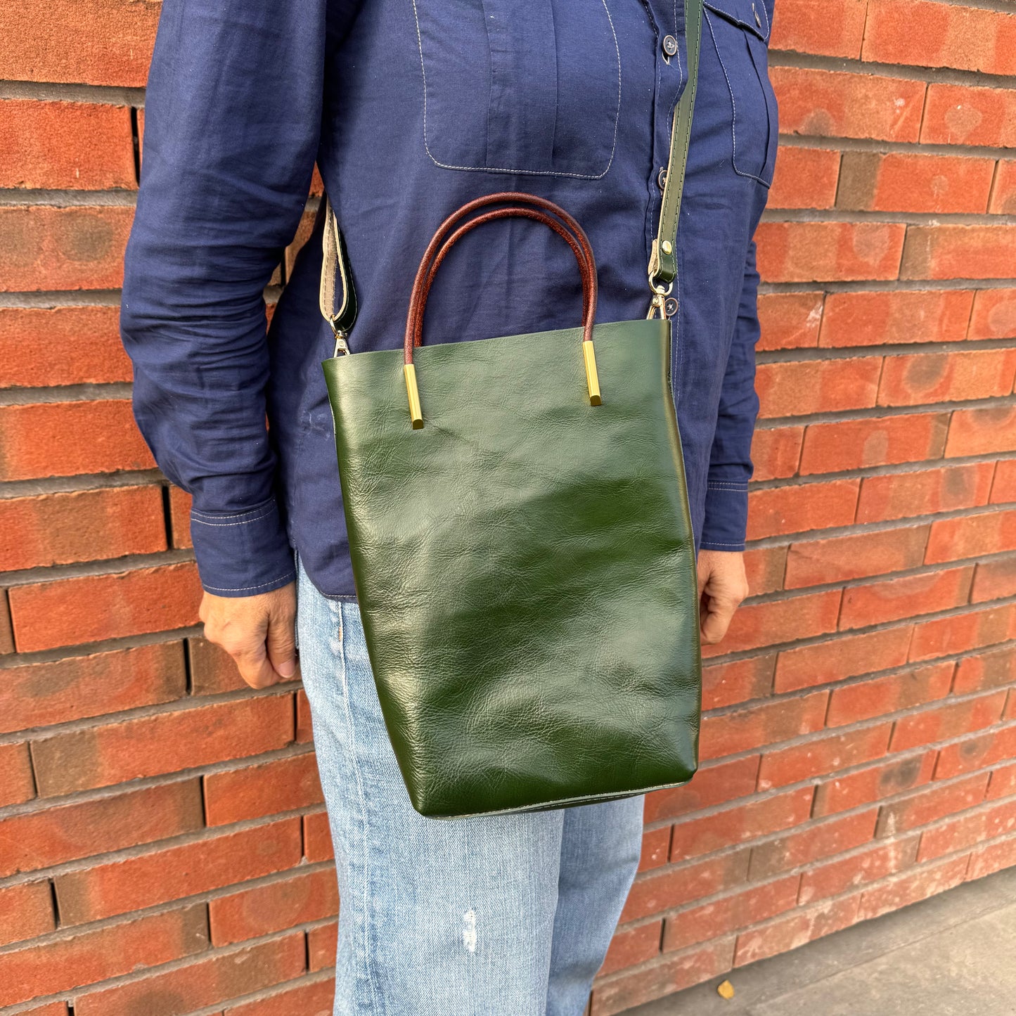 Petit sa seau en cuir, avec anse fixe et bandoulière amovible, coloris vert.