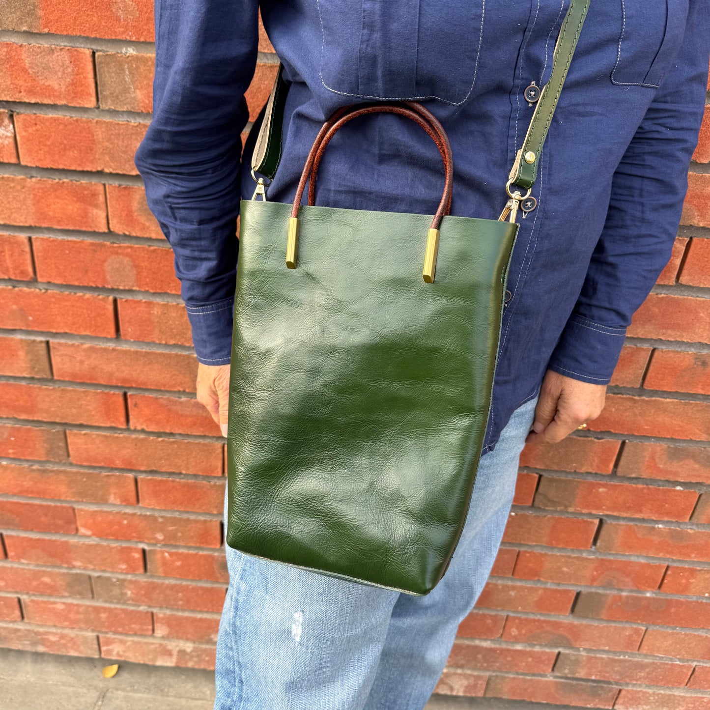 Petit sa seau en cuir, avec anse fixe et bandoulière amovible, coloris vert.