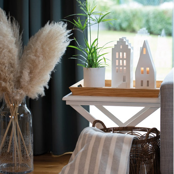 Photophore en porcelaine blanche en forme de maison avec un grand toit pentu.