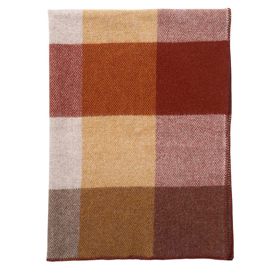 Plaid en laine d'agneau avec des grands carreaux colorés dans les tons rouges, jaunes et oranges.