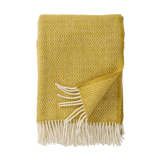 Plaid en laine d'agneau, avec motifs de chevrons jaunes.