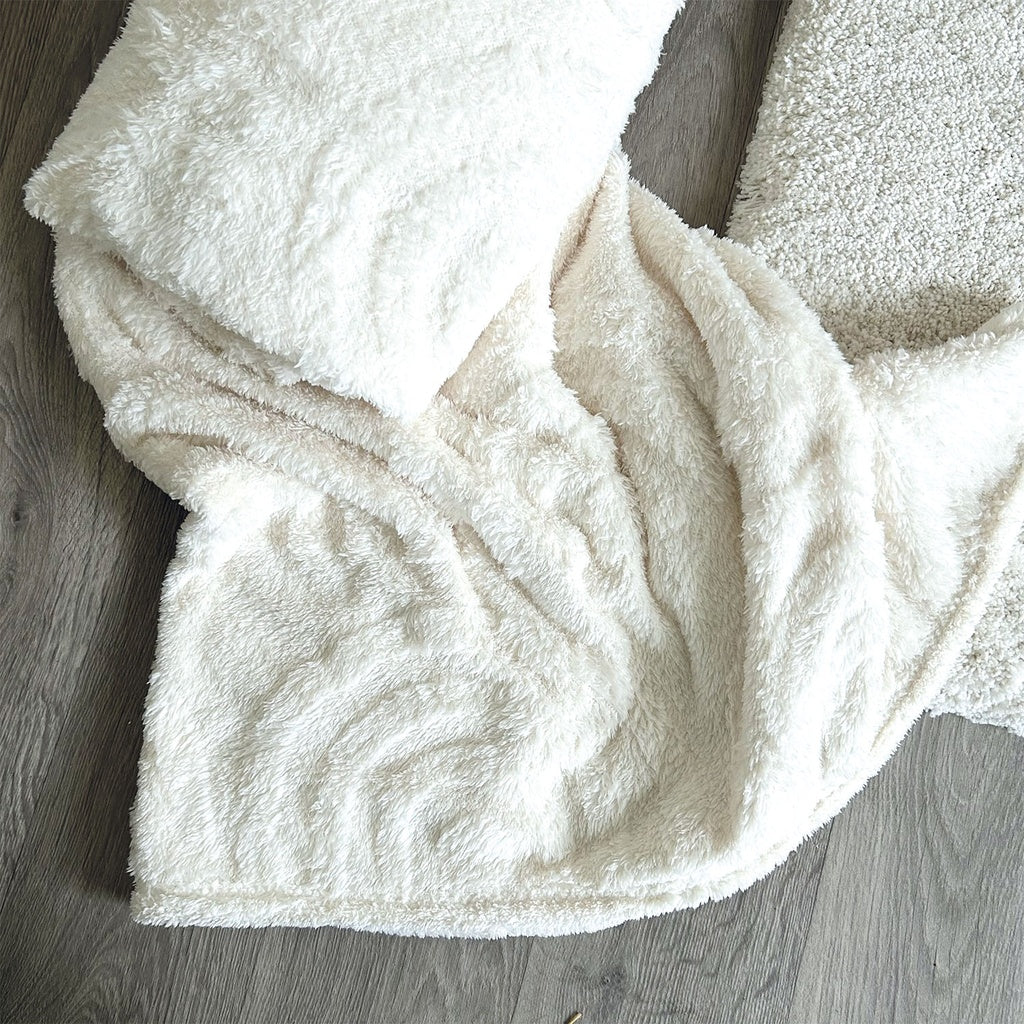 Plaid en moumoute blanc tout doux avec des motifs arc de cercles.