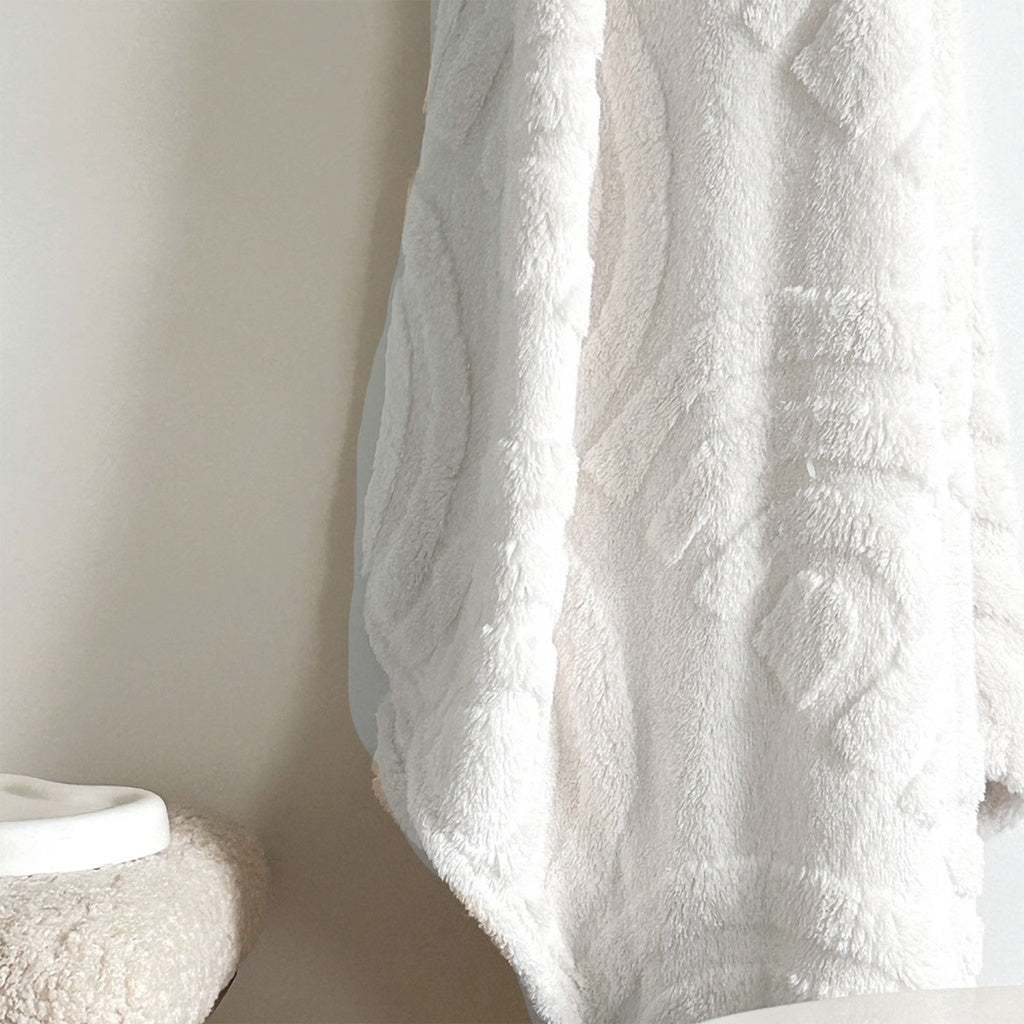 Plaid en moumoute blanc tout doux avec des motifs arc de cercles.