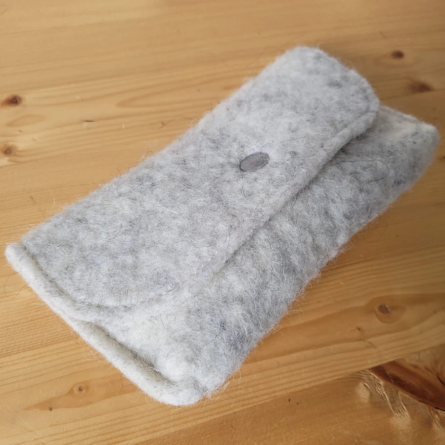 Détail d'une pochette en laine feutrée française, coloris ivoire.