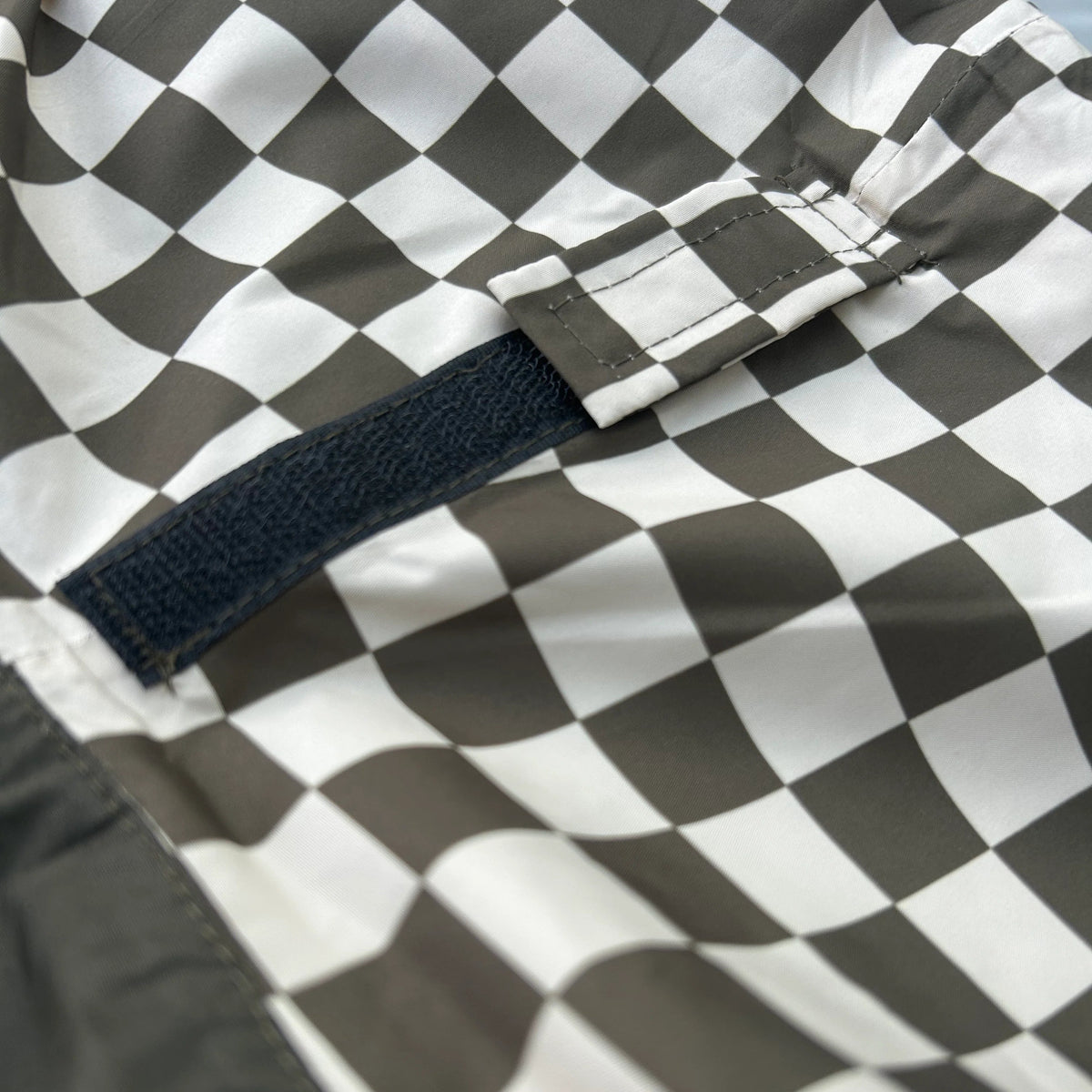 Poncho de pluie long imperméable, marron à motif damier, détail de la capuche.