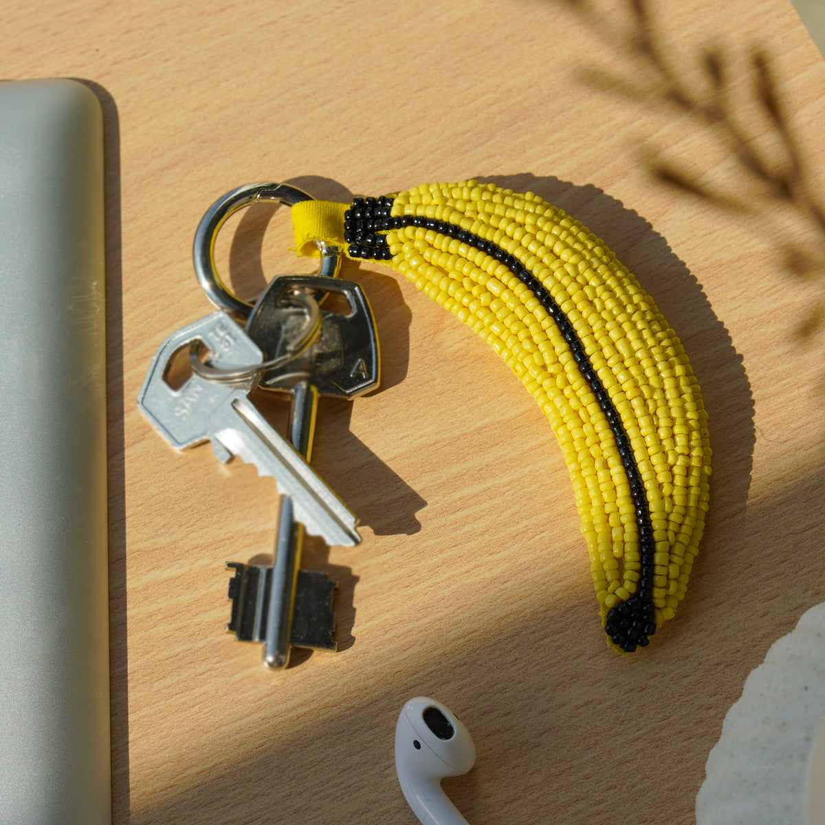Porte-clé en broderie perlée rembourrée, en forme de banane jaune. 
