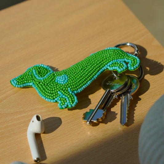 Porte-clé en broderie perlée rembourrée, en forme de chien vert et bleu.