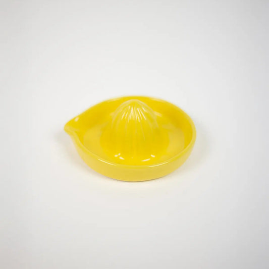 Presse-citron manuel en grès jaune, de forme ronde. 