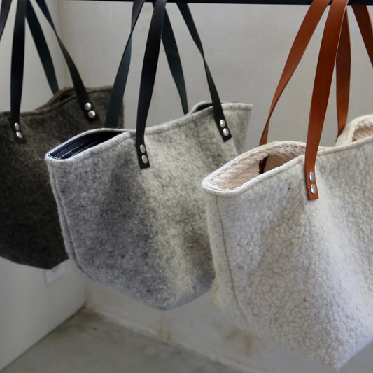 Sacs cabas en laine feutrée française, trois coloris : gris foncé, gris clair et ivoire.
