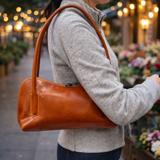 Sac baguette en cuir camel, porté. 