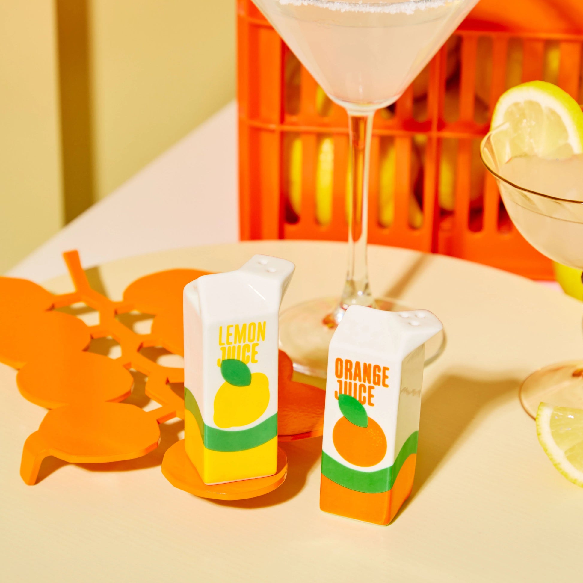 Petit set d'une salière en forme d'une brique de jus de citron jaune, et d'un poivrier en forme de brique de jus d'orange (ou inversement). 