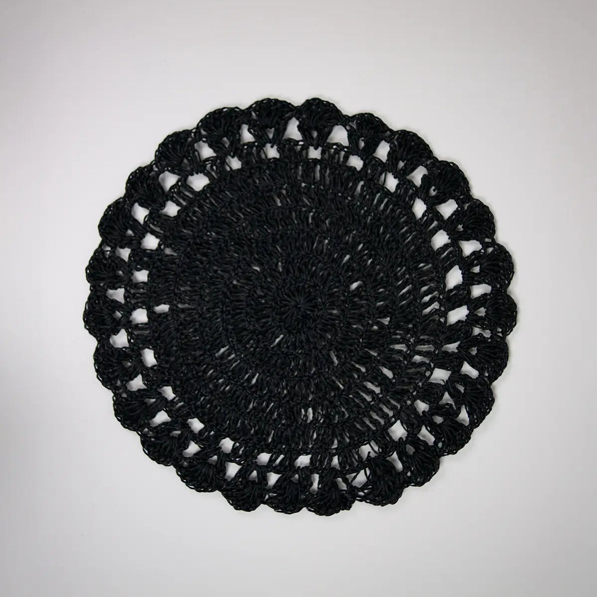 Set de table rond en raphia noir avec des détails au crochet.