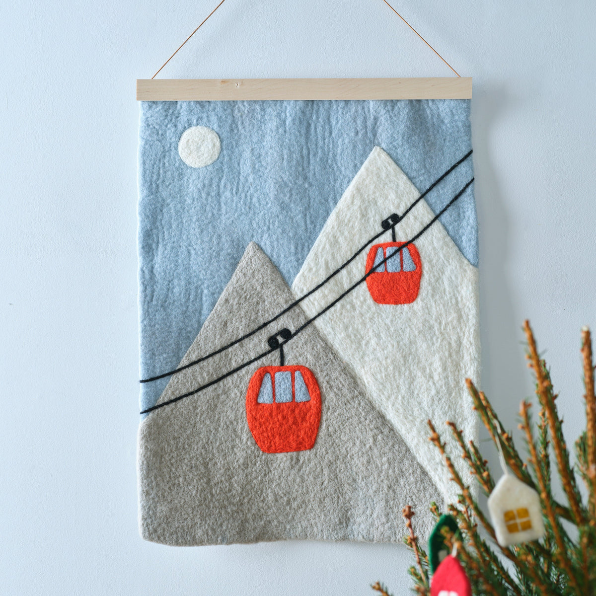 Tableau feutré en laine avec une illustration de téléphérique sur fond montagnard.