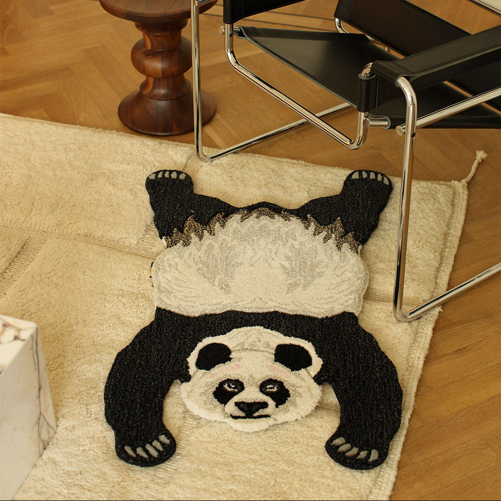 Tapis en forme de panda posé au pied d'un fauteuil.