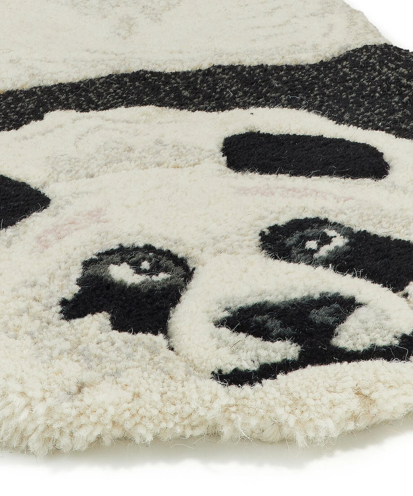 Détail zoomé de la tête du tapis en forme de panda.