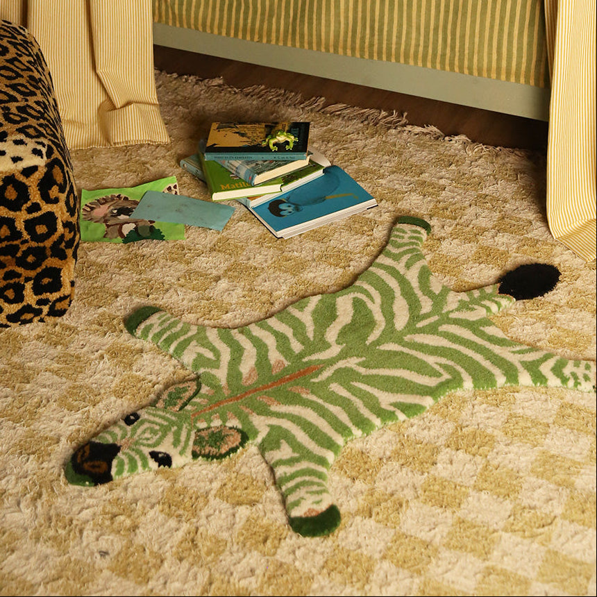 Petit tapis en laine en forme de zèbre vert.