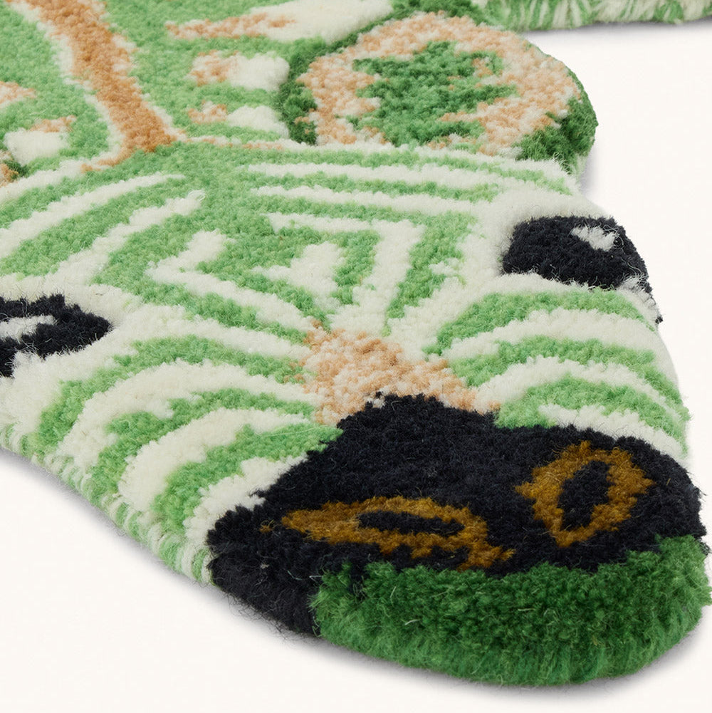 Petit tapis en laine en forme de zèbre vert.