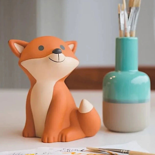 Petite tirelire en forme de renard orange.